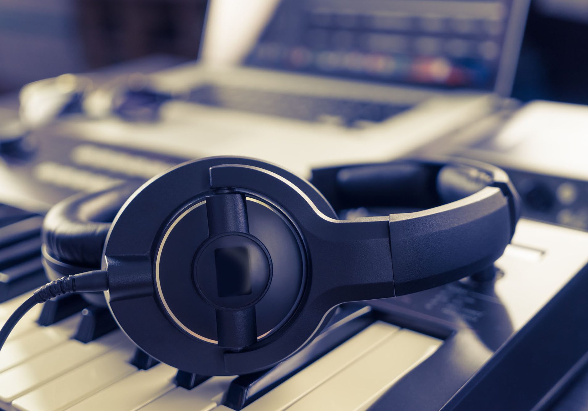 Black headphone on computer music home studio set up